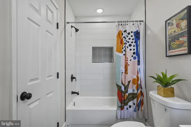 a bathroom with a toilet and a shower curtain