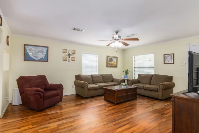 a living room with furniture and a wooden floor