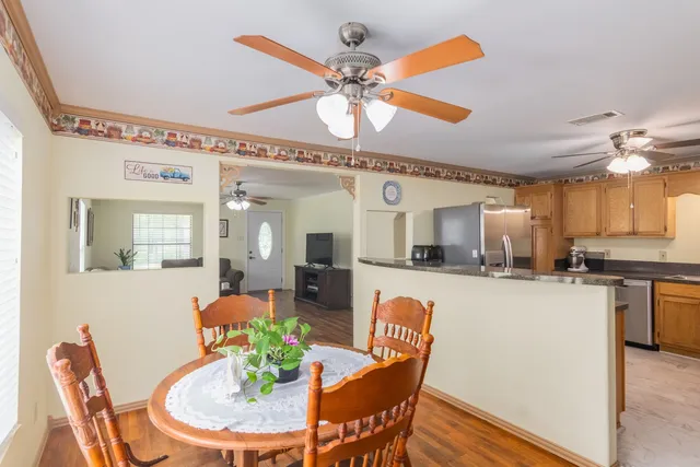a dining room filled chandelier and wooden floor