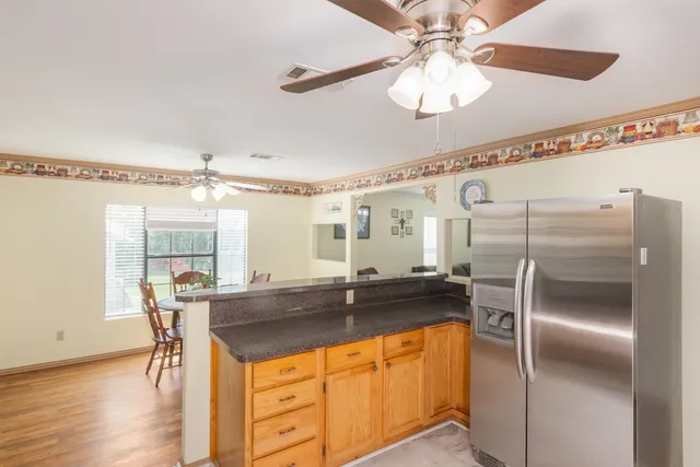 a kitchen with stainless steel appliances granite countertop a sink and a refrigerator