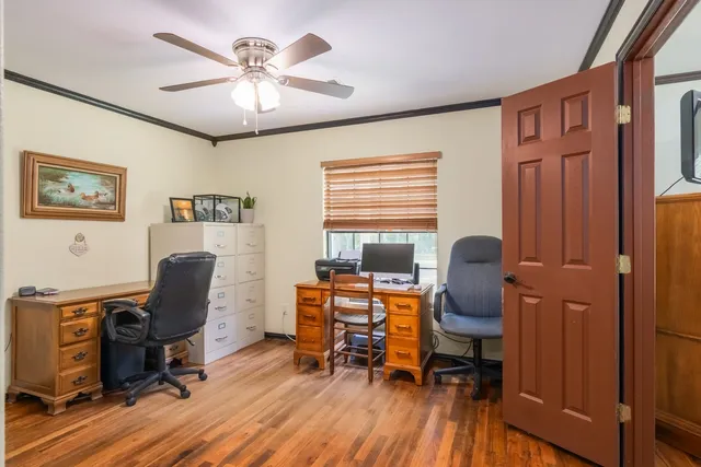a view of a workspace with furniture and a window