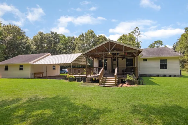 a view of a house with backyard garden and sitting area
