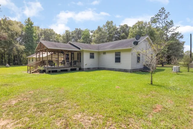 a view of a house with a backyard and a tree