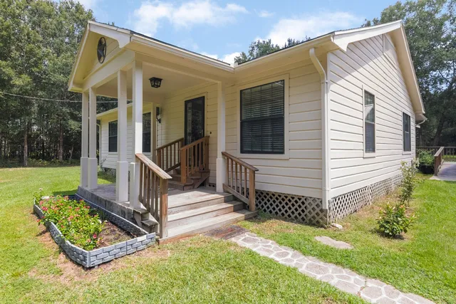 a view of a house with backyard and wooden fence