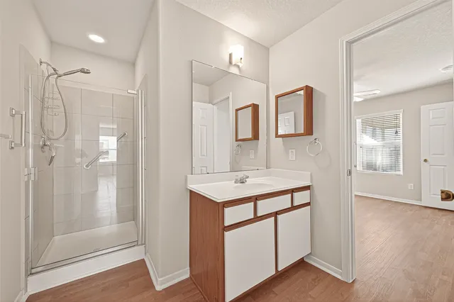 a bathroom with a shower sink and mirror