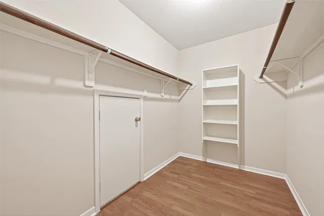 a view of walk in closet with empty racks