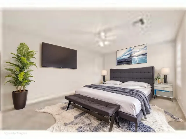 a bedroom with a bed a television and potted plant