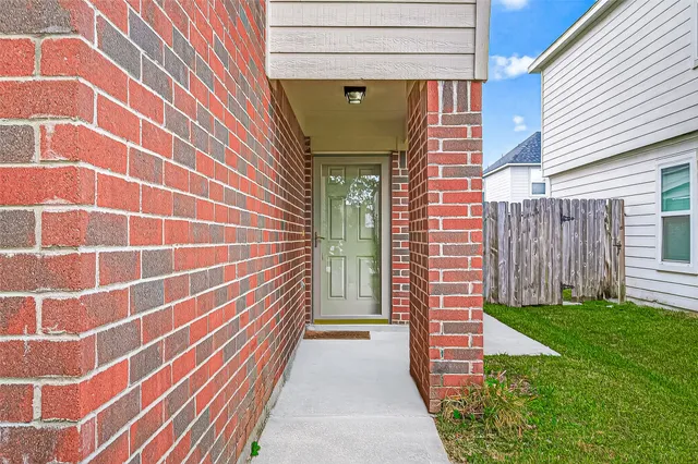 a view of a brick house with a door and a yard