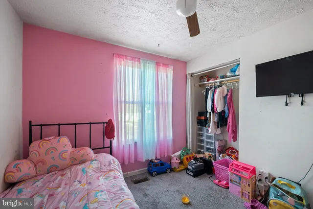 a spacious bedroom with a bed and a flat screen tv