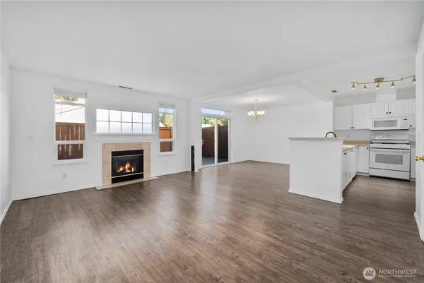 an empty room with windows and fireplace