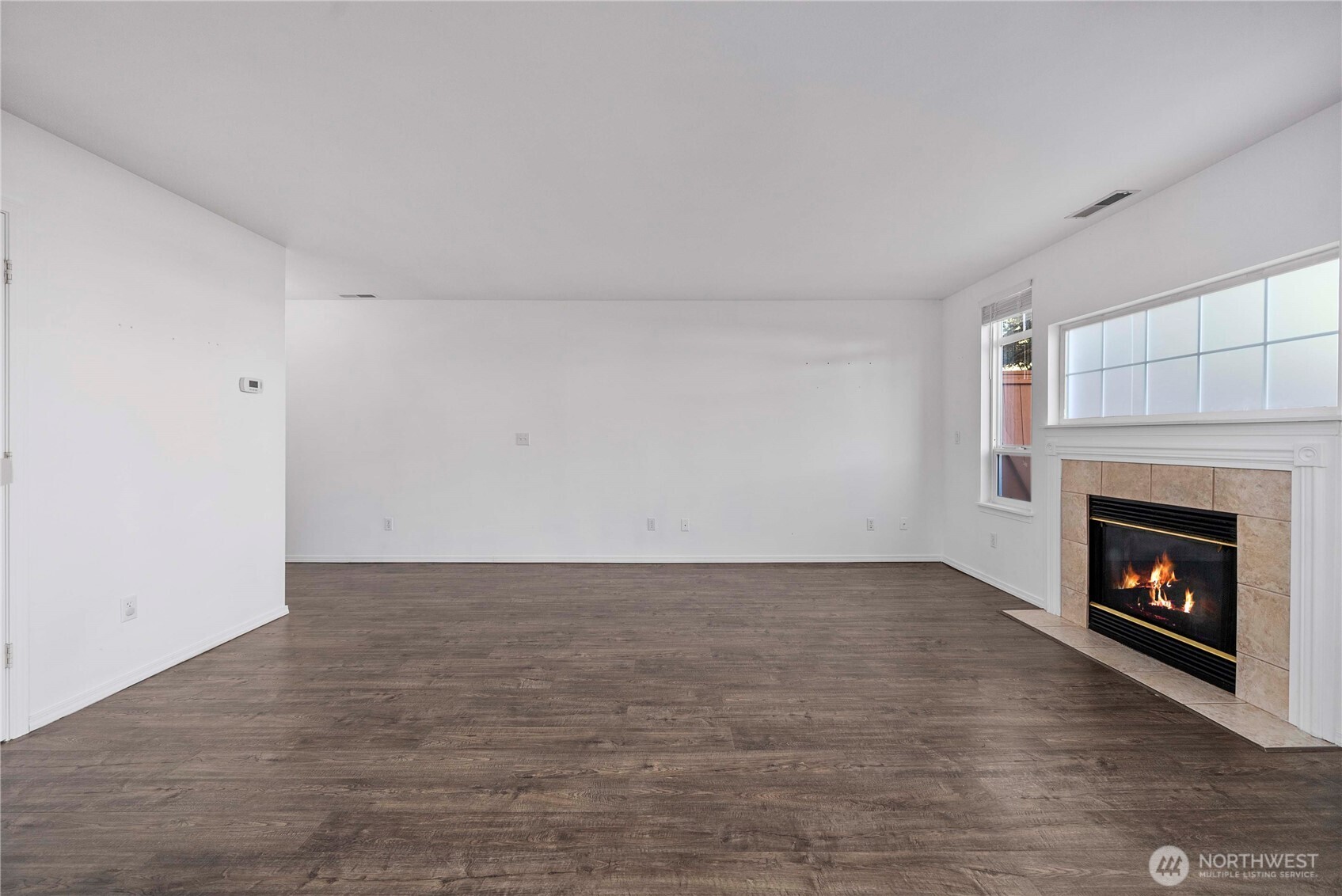 6611 Millstone Lane Southeast, Unit F101 Lacey, WA 98513 - Photo 17 of 40 a view of an empty room with wooden floor fireplace and a window