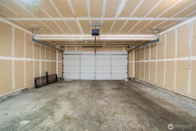 an empty room with chandelier fan and windows