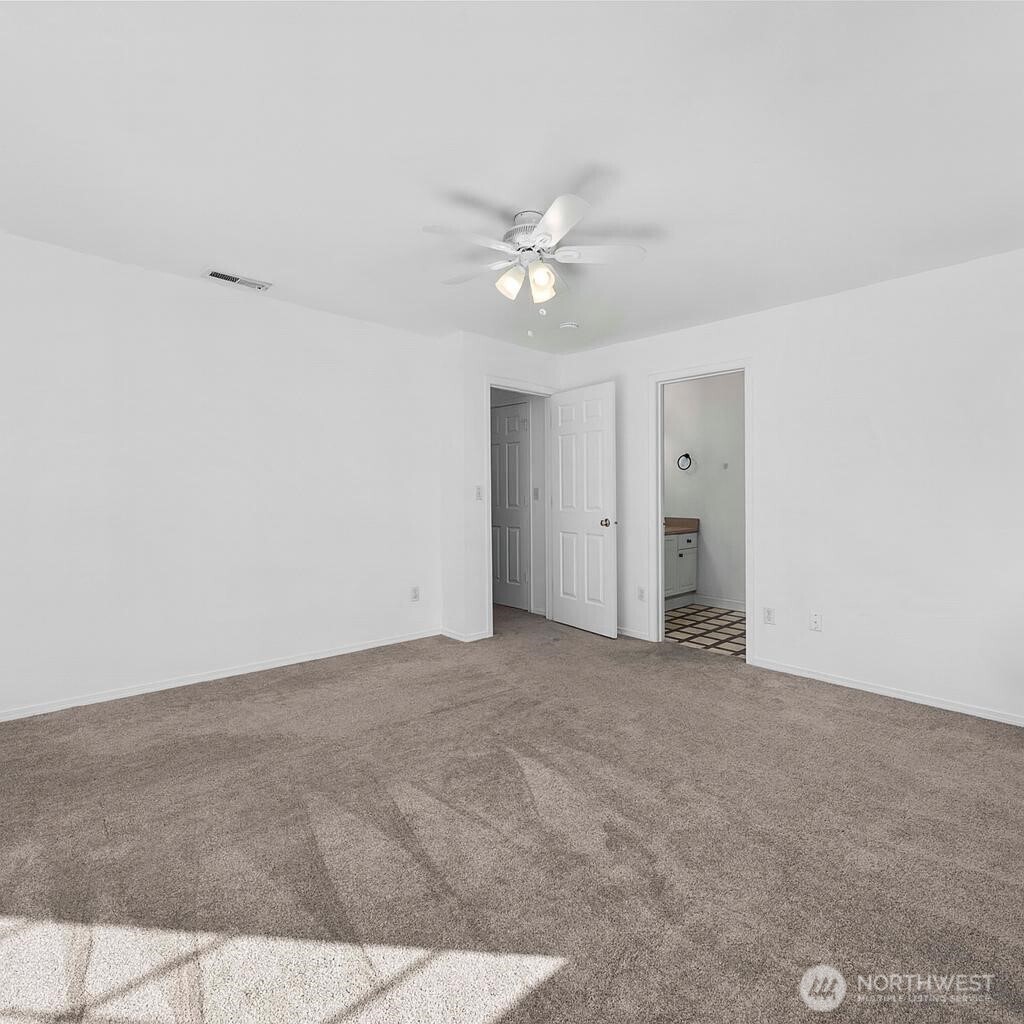 6611 Millstone Lane Southeast, Unit F101 Lacey, WA 98513 - Photo 29 of 40 an empty room with a ceiling fan and a window