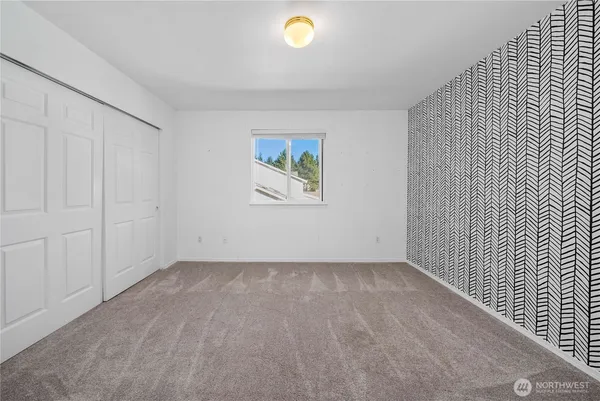an empty room with windows and palm plant