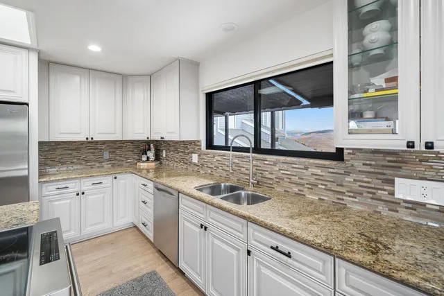 a kitchen with stainless steel appliances granite countertop a sink and a stove