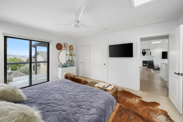 a bedroom with a large bed and a flat tv screen