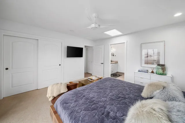 a bedroom with a large bed and a flat tv screen