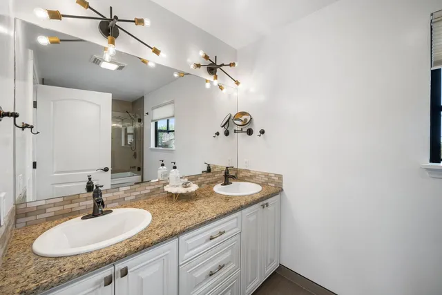a bathroom with a granite countertop sink a mirror and vanity