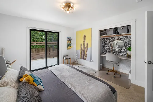 a bedroom with furniture and a large window