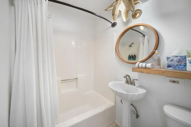 a bathroom with a sink a toilet and a mirror