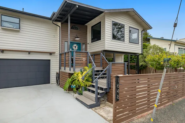 a front view of a house with plants
