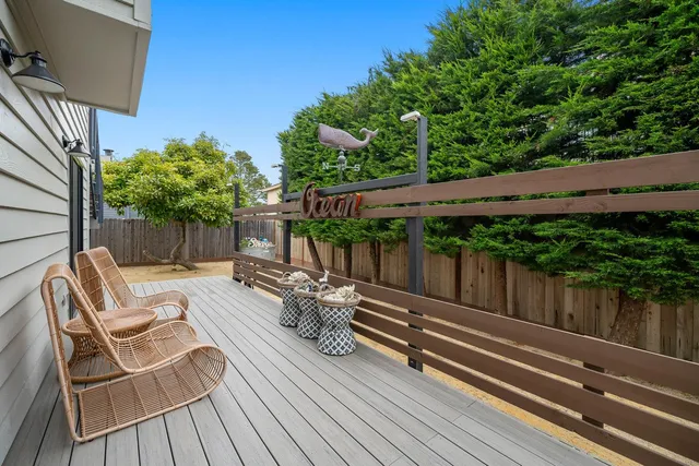 a view of backyard with deck and outdoor seating