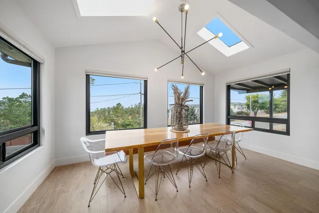 a dining room with furniture a chandelier and wooden floor