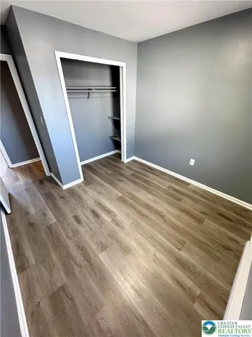 an empty room with closet and wooden floor