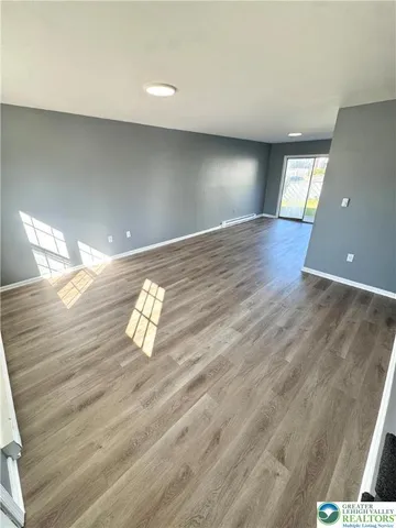 a view of empty room with wooden floor