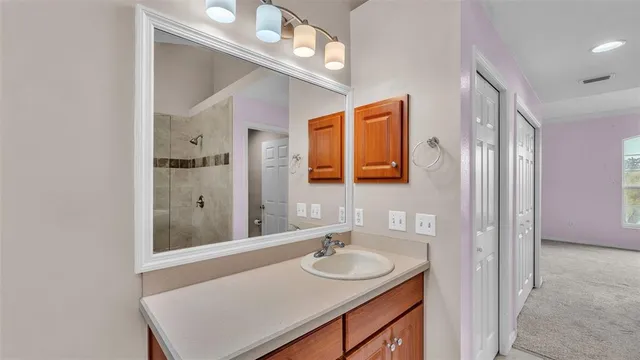 a bathroom with a sink double vanity granite tub shower and a mirror