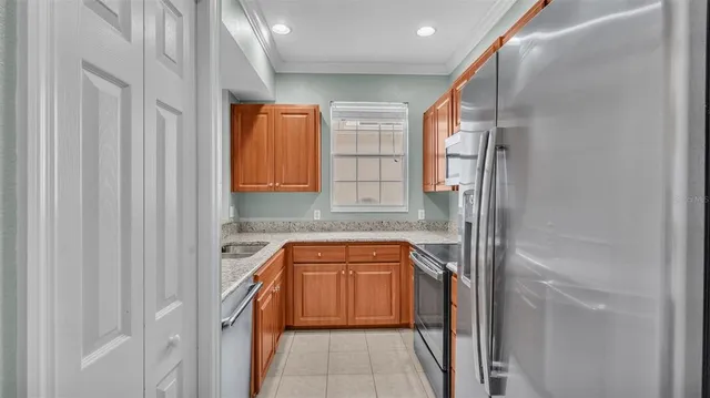 a kitchen with stainless steel appliances a refrigerator a sink a stove top oven a counter space and cabinets