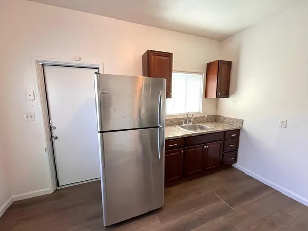 a kitchen with stainless steel appliances granite countertop a refrigerator and a sink