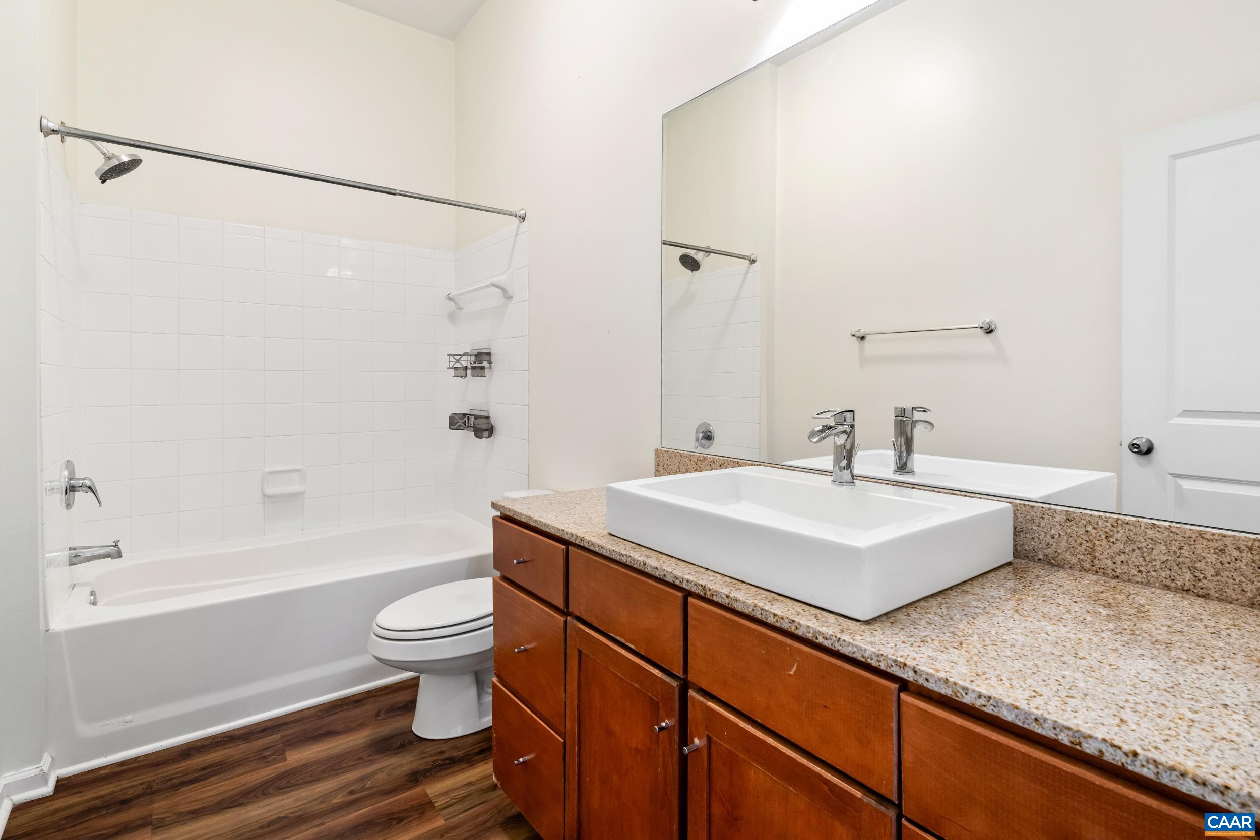 760 Walker Square, Unit 4B Charlottesville, VA 22903 - Photo 15 of 40 a bathroom with a granite countertop sink a toilet a mirror and bathtub