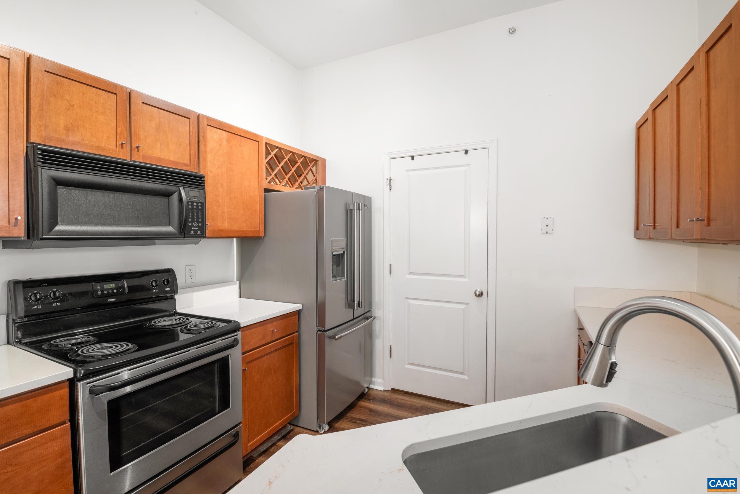 760 Walker Square, Unit 4B Charlottesville, VA 22903 - Photo 2 of 40 a kitchen with stainless steel appliances kitchen island a stove a sink and a microwave