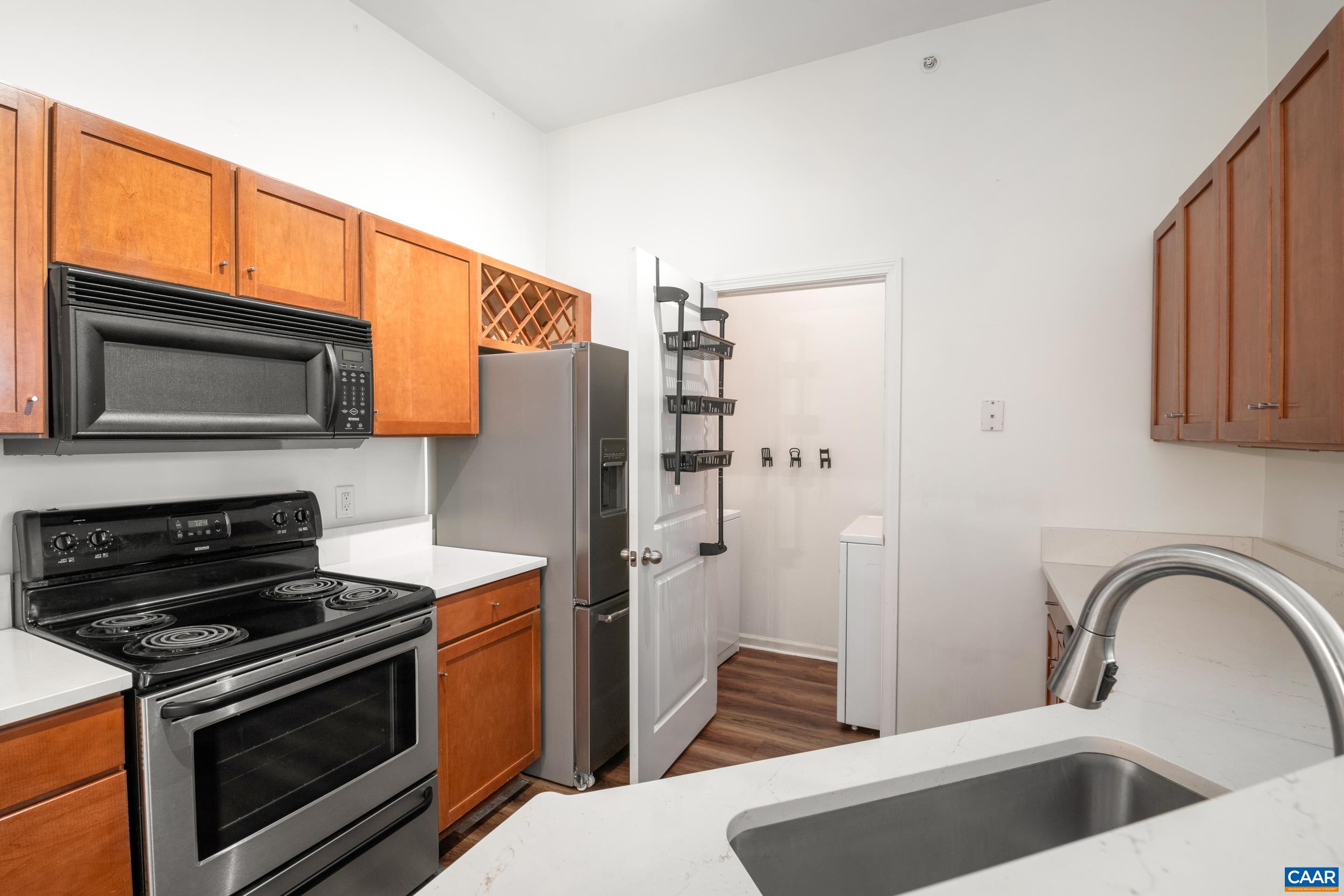 760 Walker Square, Unit 4B Charlottesville, VA 22903 - Photo 3 of 40 a kitchen with stainless steel appliances a stove a sink and a microwave
