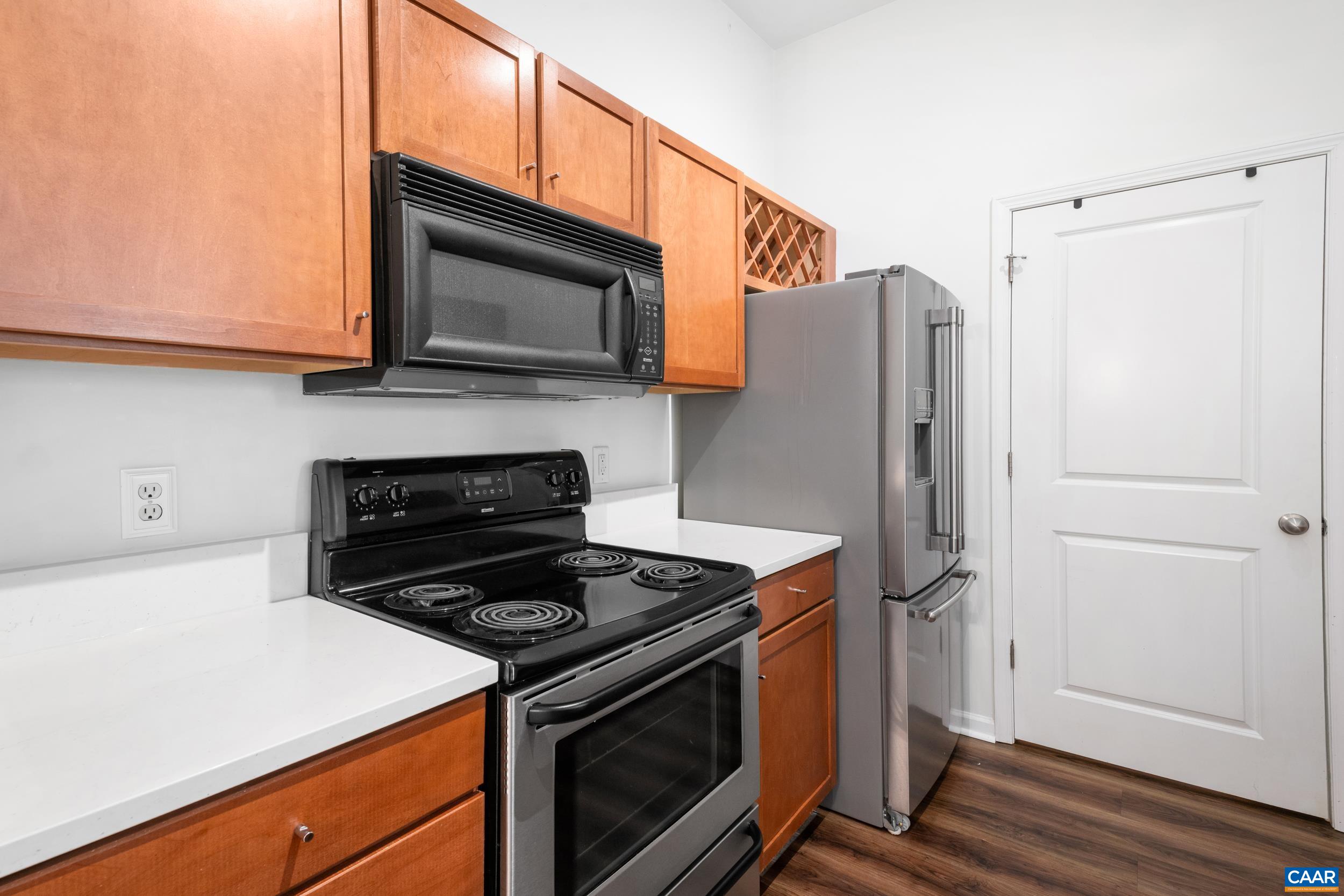 760 Walker Square, Unit 4B Charlottesville, VA 22903 - Photo 5 of 40 a kitchen with stainless steel appliances white cabinets and a stove top oven