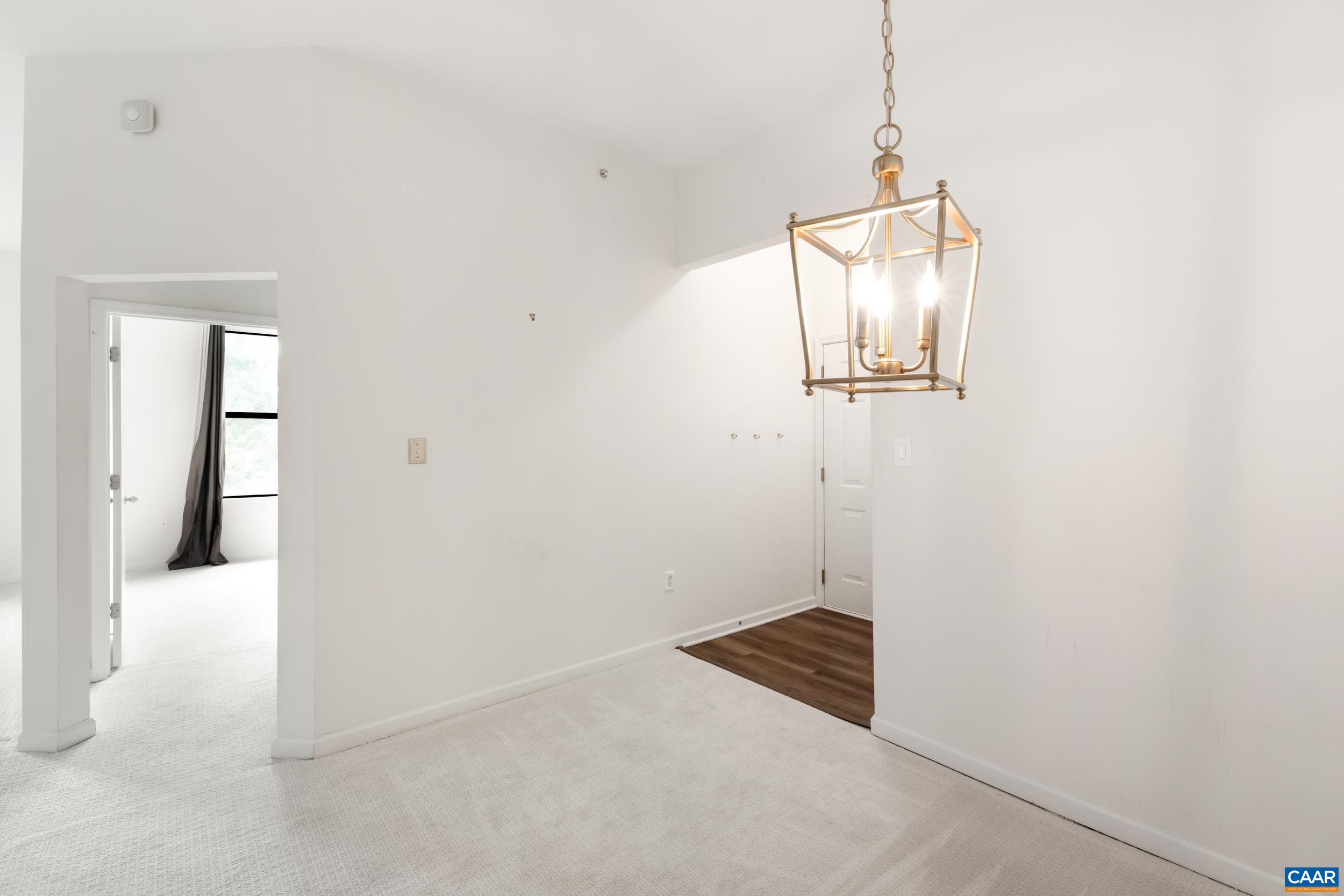 760 Walker Square, Unit 4B Charlottesville, VA 22903 - Photo 7 of 40 an empty room with wooden floor and mirror