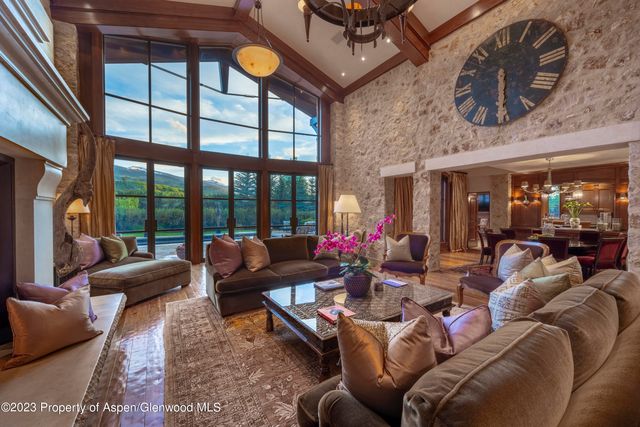 a living room with furniture a floor to ceiling window and a flat screen tv