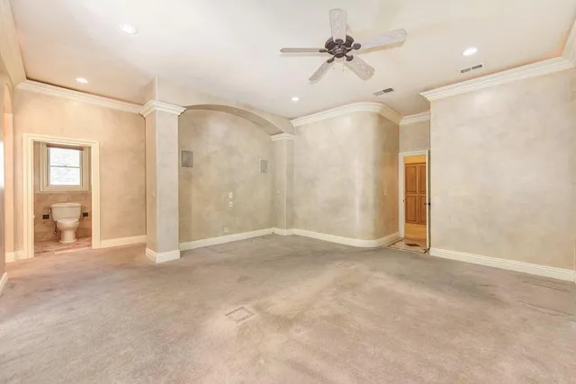 a view of an empty room with a ceiling fan