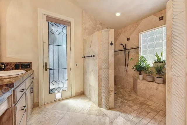 a spacious bathroom with a granite countertop shower a mirror and a sink