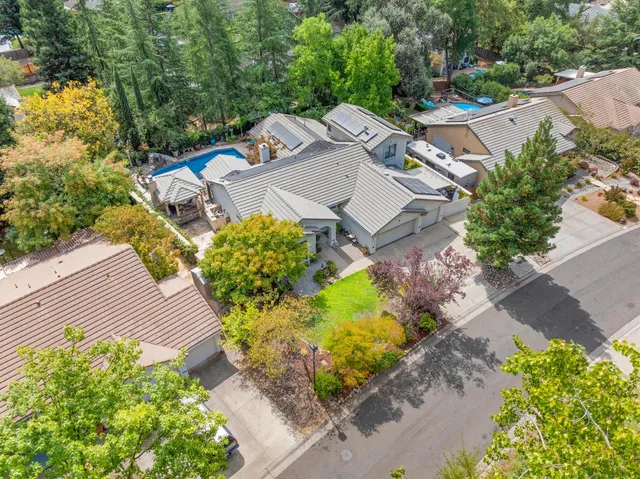 an aerial view of a house with a yard and a large tree