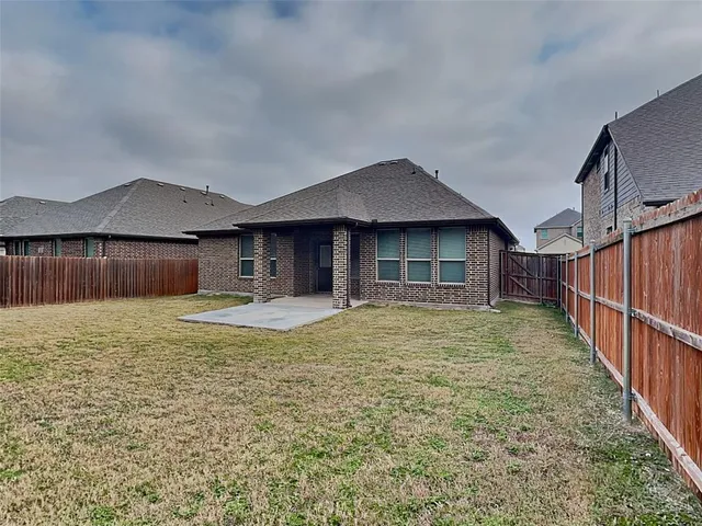 a view of a house with a yard and wooden fence