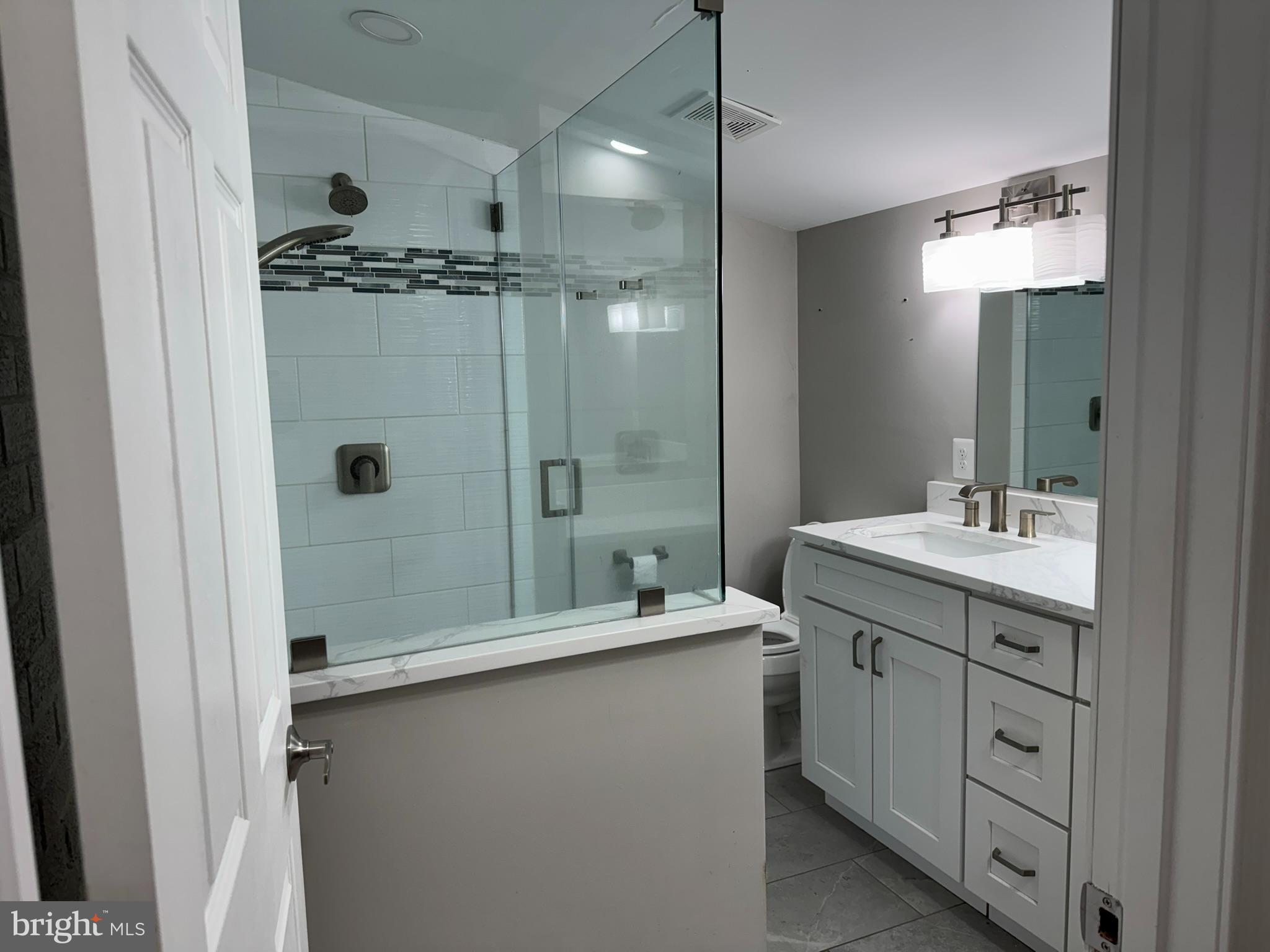 10012 Ellis Road Manassas, VA 20111 - Photo 17 of 71 a bathroom with a double vanity sink a mirror and a shower