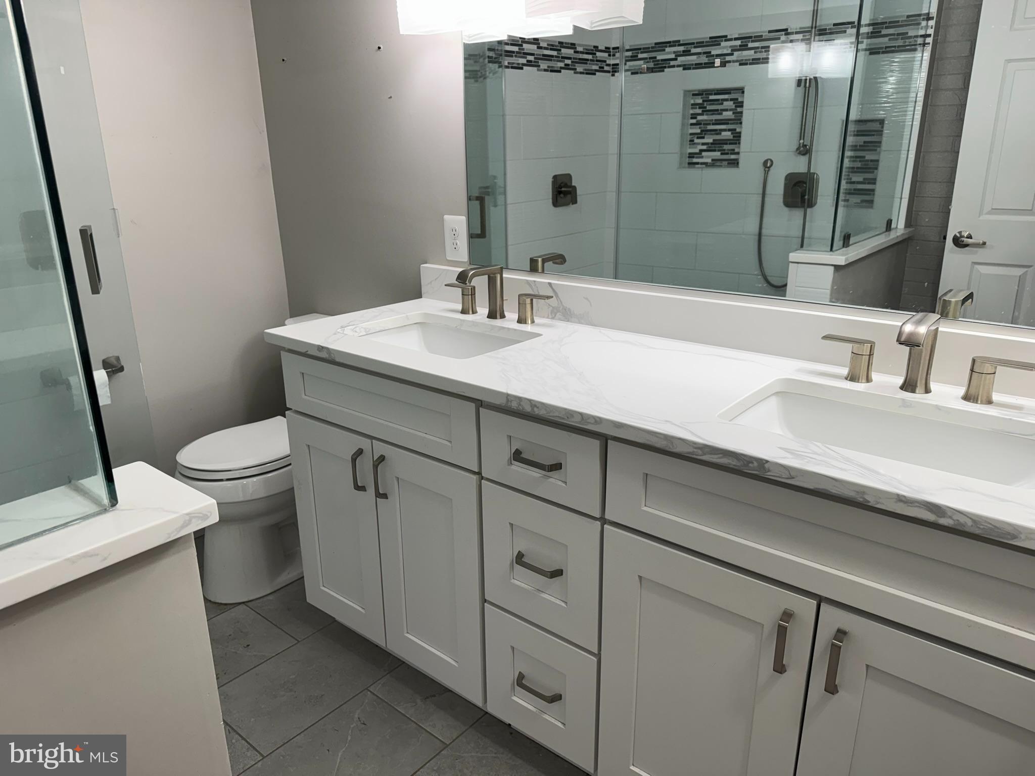 10012 Ellis Road Manassas, VA 20111 - Photo 19 of 71 a bathroom with a granite countertop toilet sink and mirror