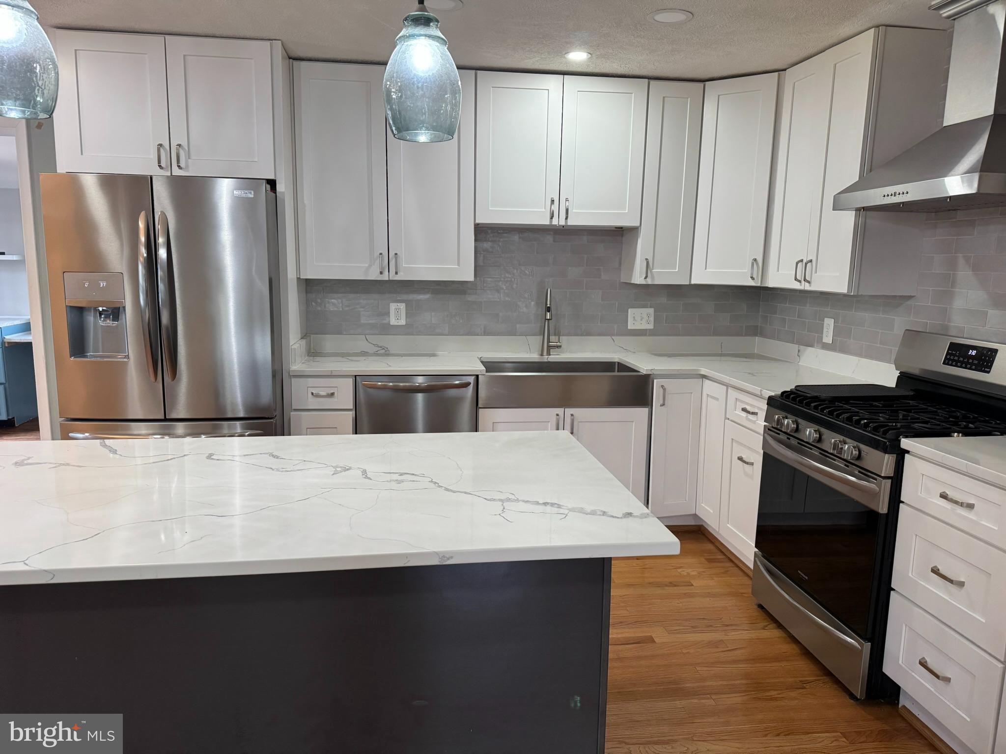 10012 Ellis Road Manassas, VA 20111 - Photo 3 of 71 a kitchen with stainless steel appliances a sink dishwasher a refrigerator a stove and white cabinets with wooden floor