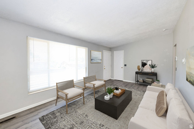 1272 Cook Street Ogden, UT 84404 - Photo 8 of 58 Spacious living area featuring a large window with blinds, wood-finish flooring, and a vaulted ceiling