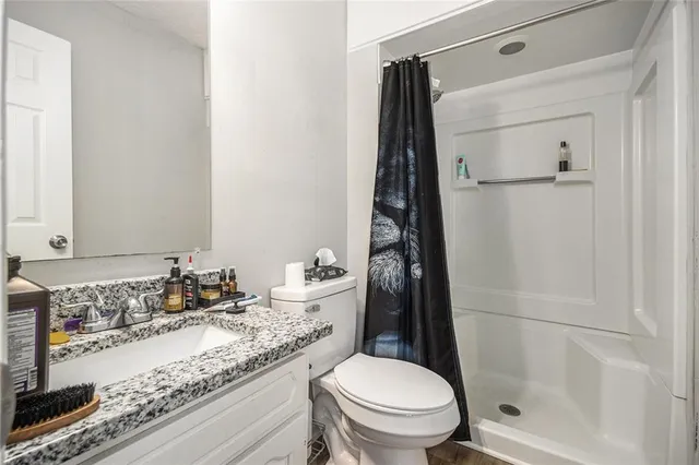 a bathroom with a granite countertop sink toilet and shower