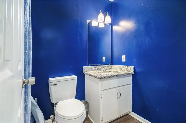 a bathroom with a granite countertop toilet sink and mirror