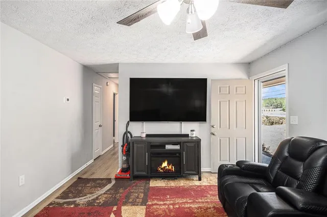 a living room with furniture a flat screen tv and a fireplace