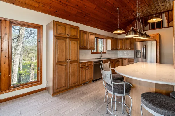 a kitchen with stainless steel appliances wooden cabinets a sink and a refrigerator